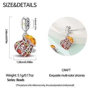 Detailed view of silver heart pirate coin pouch charm with red enamel and skull motif