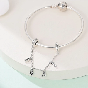 Dettaglio del bracciale in argento con catena di sicurezza a note musicali e chiusura incisa