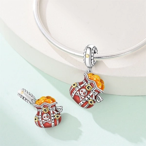 Detail of a red pirate money bag charm with skull and gold coins for bracelets