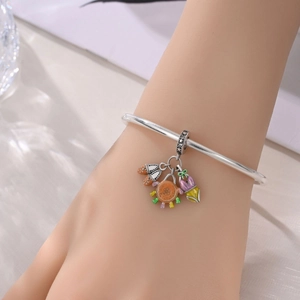 Detail of silver bangle with enamel beach charms like sun crab and flip-flops