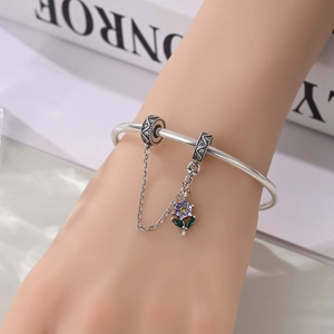 Dettaglio charm con catena di sicurezza in argento e ciondolo a fiore in zircone viola