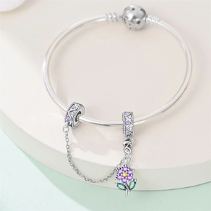 Dettaglio del bracciale con catena di sicurezza argento e ciondolo fiore in zircone viola