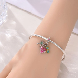Detail of silver charm bracelet with palm tree, bikini, and colorful enamel pendants