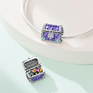 Purple treasure chest charm with colorful gemstones on a silver-plated bracelet