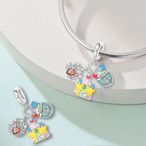 Close-up of beach-themed silver charms with crab, castle, and bucket on bracelet