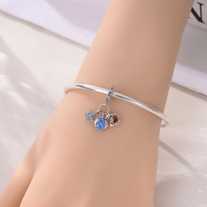 Silver bracelet with blue starfish charm and colorful gemstones on a model's wrist