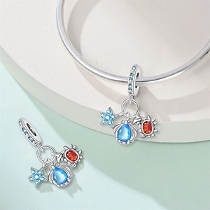 Detail of beach themed silver charm with blue starfish, shell and crab for bracelets
