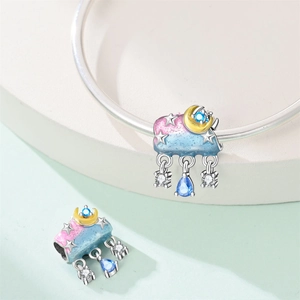 Detailed view of silver cloud charm with blue and pink enamel and hanging gemstones