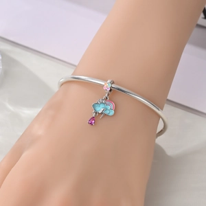 Detail of silver-plated bracelet with rainbow charm and colorful enamel lightning motifs