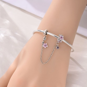 Dettaglio del bracciale snake argento con ciondoli fiori smaltati rosa e catena di sicurezza