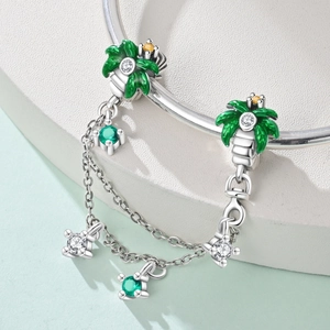 Detailed close-up of a silver palm tree charm with green enamel and vibrant colorful zircons