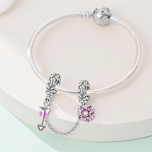 Dettaglio catena di sicurezza in argento con fiore in smalto rosa e freccia su bracciale