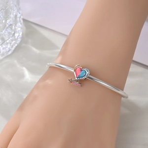 Detail of silver heart charm with red and blue enamel and SUNNY engraving on bracelet