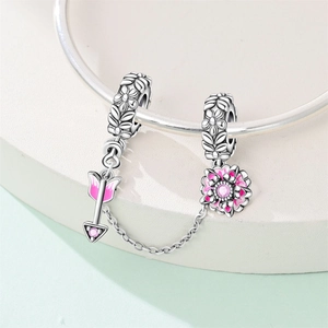 Dettaglio catena di sicurezza in argento con freccia in smalto rosa e ciondolo a fiore