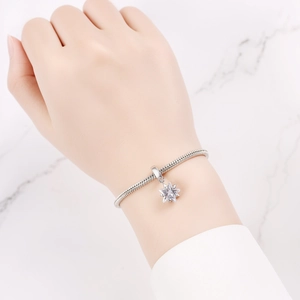 Primer plano de pulsera con dije de estrella y circonita en cadena de serpiente plateada
