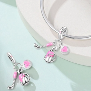 Macro detail of silver golf charms with a pink heart pendant and golf bag on a ring