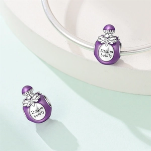 Detail of purple enamel perfume bottle charms with Dream Boldly engraving on silver bracelet