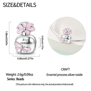 Macro detail of silver charm bead with pink dragonfly, flower and Style remains engraving