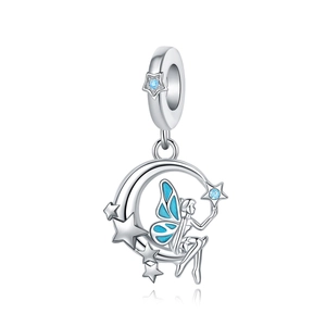 Detalle macro de dije de plata con hada de esmalte azul sentada en una luna creciente