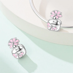 Detail of silver charm bead with pink enamel dragonfly and Style remains engraving