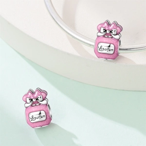 Detailed view of pink enamel perfume bottle charm with bow on a silver bracelet