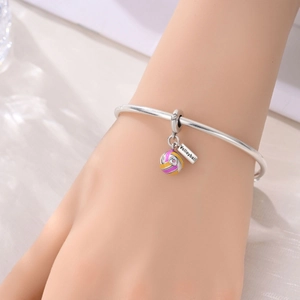 Silver bracelet detail showing enamel volleyball charm and engraved volleyball tag