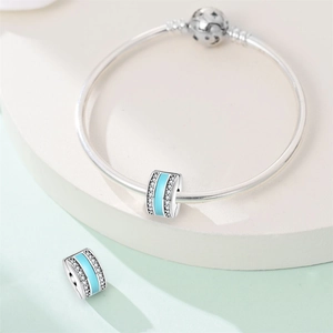 Macro shot of silver charm bracelet with blue enamel band and starry moon buckle closure