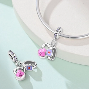 Macro detail of silver kettlebell charm with pink enamel 88KG print and purple zircon stones