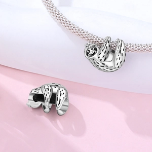 Gros plan d'une breloque paresseux en argent sur un bracelet en maille pour femme