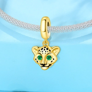 Gros plan détaillé du pendentif léopard doré aux yeux verts et taches en émail noir