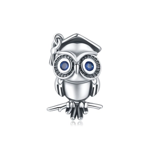 Vue détaillée du charme hibou en argent avec toque de diplômé et yeux en gemmes bleues
