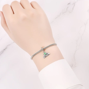 Makroaufnahme von Silber-Insektenanhänger mit grünem Edelstein am Schlangenarmband