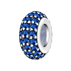 Dettaglio di un charm in argento con micro-pavé di gemme blu tonde e brillanti