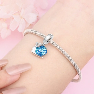 Bracelet plaqué argent avec pendentif escargot en émail bleu porté au poignet