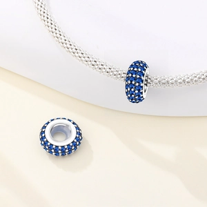 Dettaglio charm distanziatore in argento con zirconi blu su bracciale mesh