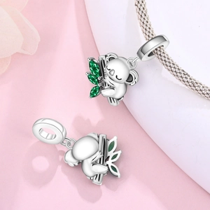 Gros plan d'un charm koala en argent avec feuille de zircon vert sur un bracelet