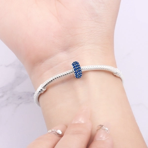 Dettaglio di un distanziatore placcato argento su bracciale a serpente con zircone blu