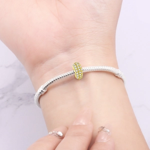 Dettaglio del bracciale a catena snake con charm dorato e zirconi indossato al polso