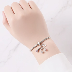 Close-up of music themed silver charm bracelet with microphone and headphone charms