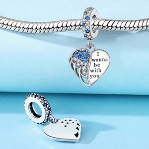 Macro detail of silver heart charm with blue zircons and I wanna be with you engraving