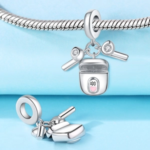 Macro detail of silver-plated bluetooth earphone charm with zircon and 100-mark design