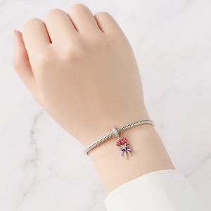 Detalle macro de la pulsera de cadena de serpiente plateada con corazones y lazo lila