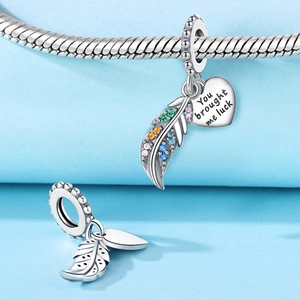 Detail of silver feather charm with colorful zircons and engraved heart lucky pendant