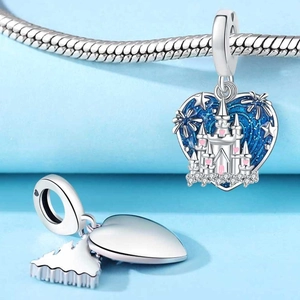 Macro detail of silver heart charm with blue glitter enamel and castle engraving