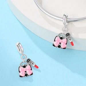 Silver charm set with a pink bow handbag and a red lipstick on a beaded bracelet