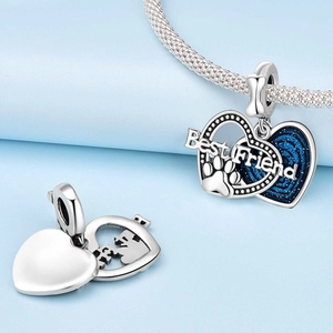 Detalle de dije de corazón plateado con grabado Best Friend y purpurina azul estelar