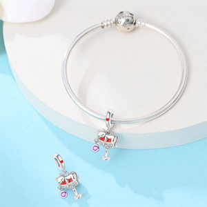 Detail of silver cat pendant on bangle with 'We belong together' engraving on the clasp