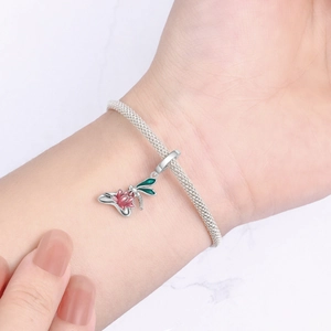 Nahaufnahme von Silberarmband mit Libellen- und Blumenanhängern aus Emaille