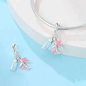 Detail of silver travel charms with airplane and pink cherry blossom designs