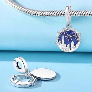 Macro detail of city night sky charm with blue enamel fireworks and silver skyscrapers